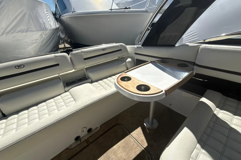 Slide: The Image of Interior of a 2020 Cobalt R30 boat with white seating and a wooden table. - 19