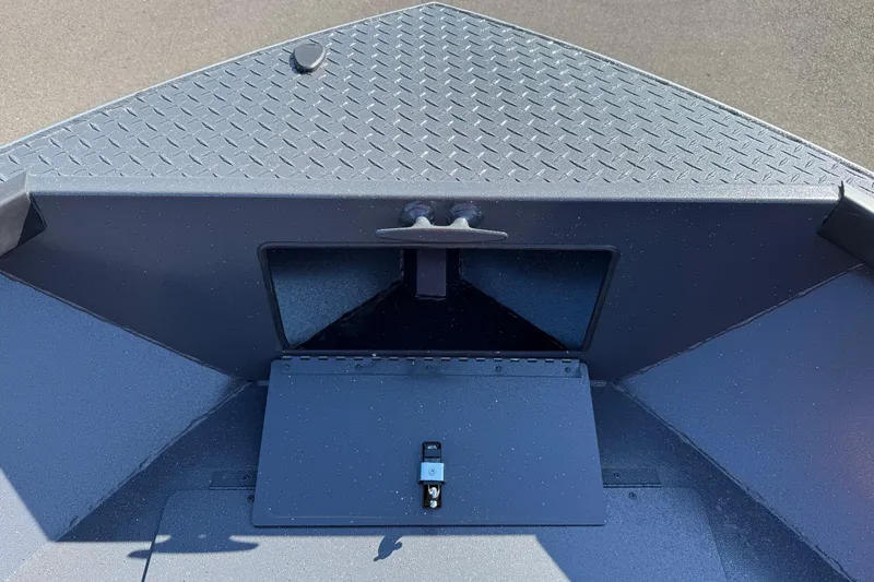 Slide: The Image of 2025 Alumaweld Adventurer 22 boat interior with storage compartment and diamond plate flooring. - 8
