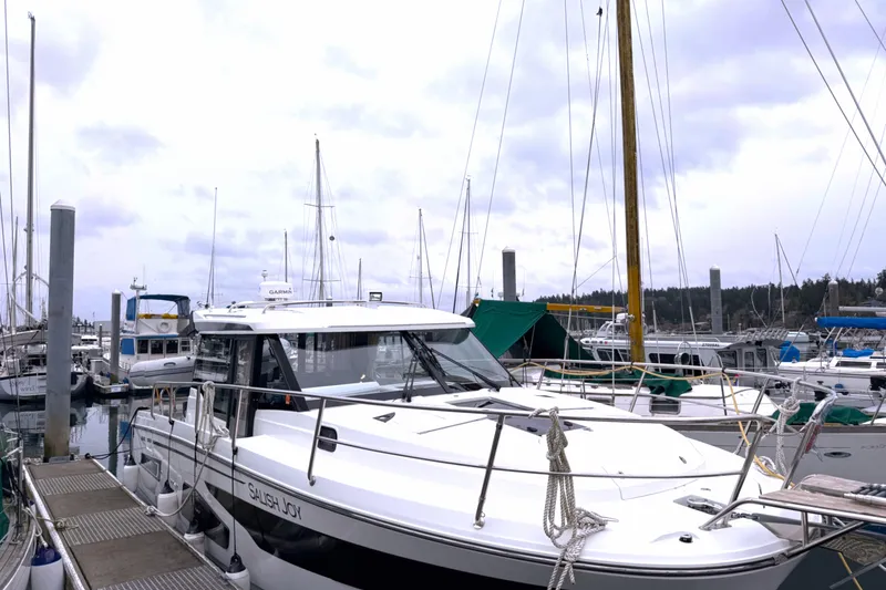 The Image of 2023 Jeanneau NC 1095 boat docked in a marina with other vessels. - 0