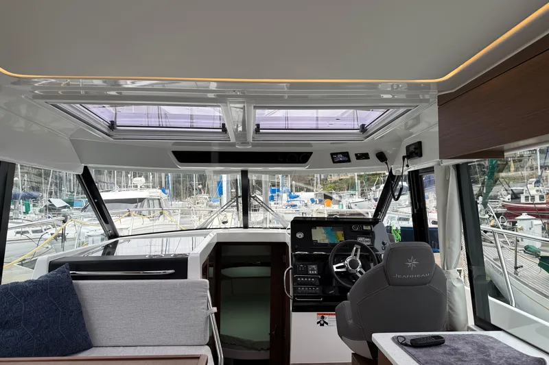 Slide: The Image of Interior view of 2023 Jeanneau NC 1095 boat cockpit with modern controls and seating. - 12
