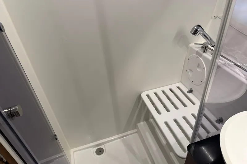 Slide: The Image of 2023 Jeanneau NC 1095 boat bathroom with shower and white fixtures. - 27