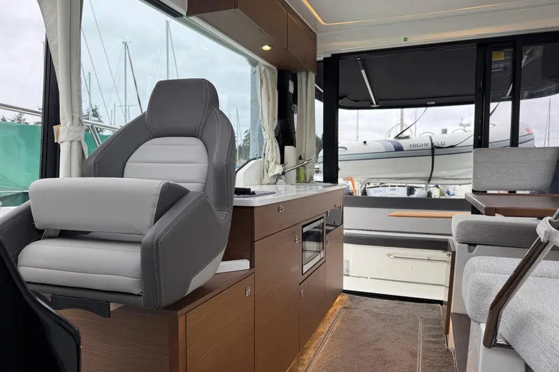 Slide: The Image of Interior of 2023 Jeanneau NC 1095 boat with modern seating and kitchen area. - 29
