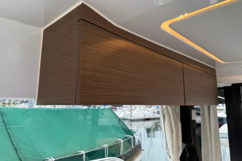 Slide: The Image of Interior of 2023 Jeanneau NC 1095 boat with sleek wooden cabinetry and modern lighting. - 35