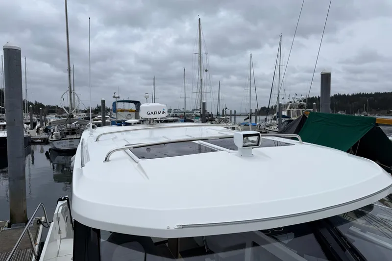Slide: The Image of 2023 Jeanneau NC 1095 boat docked at a marina with overcast skies. - 39