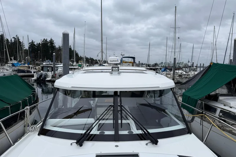 Slide: The Image of 2023 Jeanneau NC 1095 docked at a marina under cloudy skies. - 40