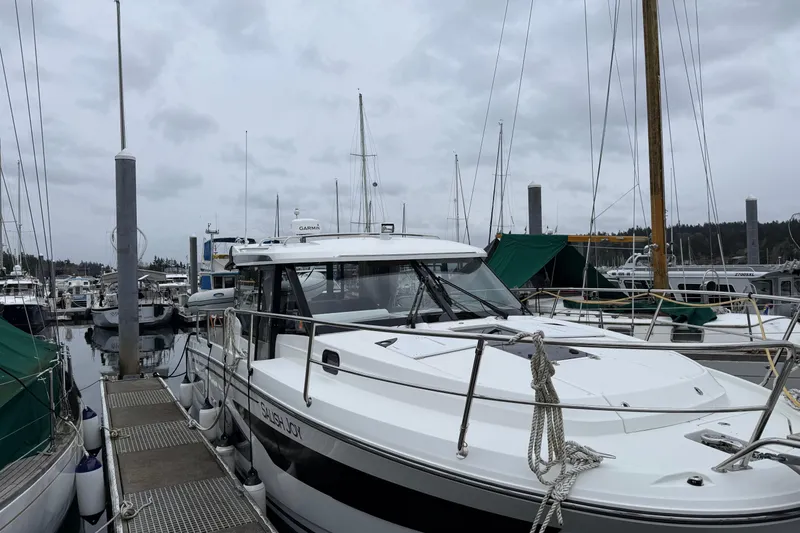Slide: The Image of 2023 Jeanneau NC 1095 boat docked at a marina under cloudy skies. - 41