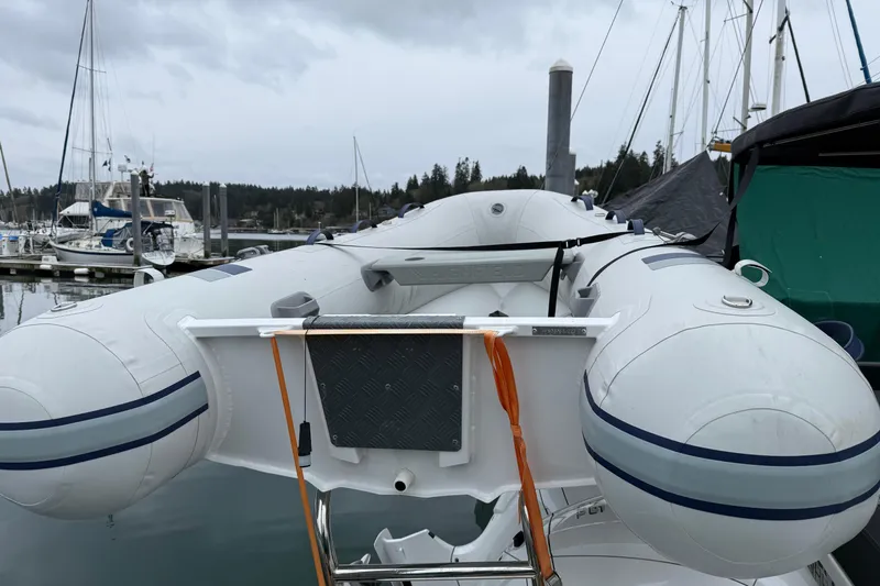 Slide: The Image of Inflatable boat docked near Jeanneau NC 1095, 2023 model, in a marina setting. - 5