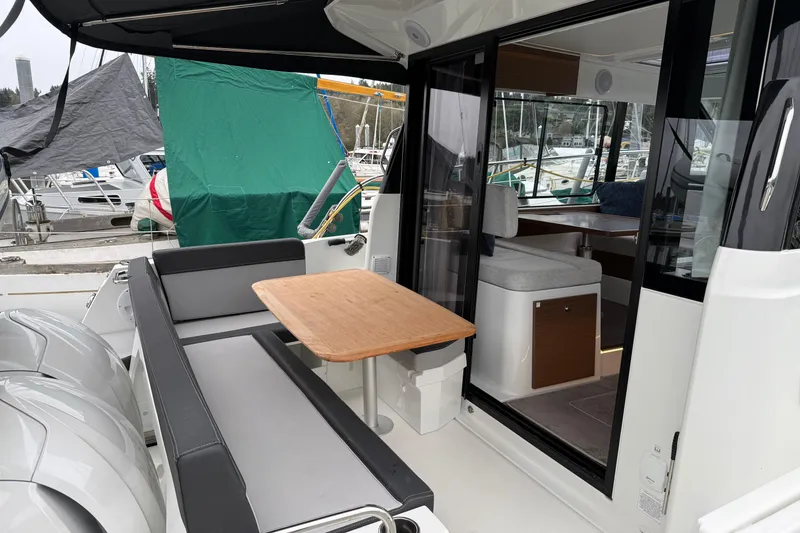 Slide: The Image of 2023 Jeanneau NC 1095 boat interior with seating and table, docked at marina. - 8