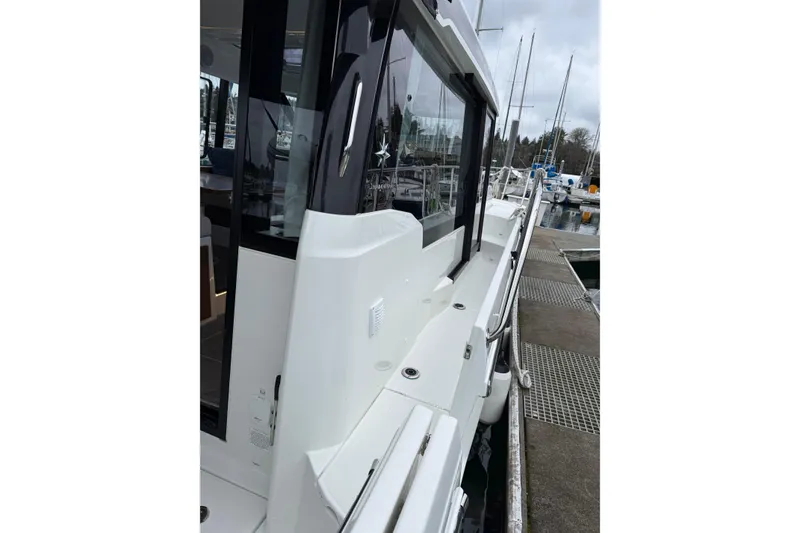 Slide: The Image of 2023 Jeanneau NC 1095 yacht docked at marina, showcasing sleek design and modern features. - 9