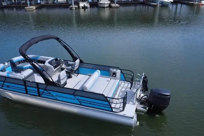 Slide: The Image of 2026 Berkshire CTS Series 24UL pontoon boat on calm water, featuring modern design and seating. - 13