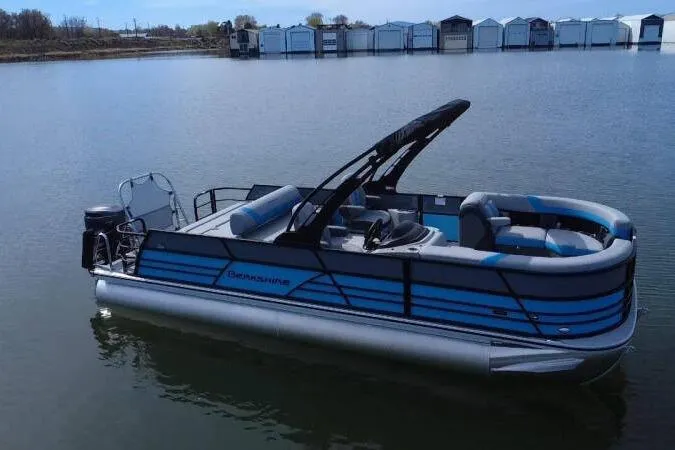 Slide: The Image of 2026 Berkshire CTS Series 24UL pontoon boat on calm lake with marina backdrop. - 3