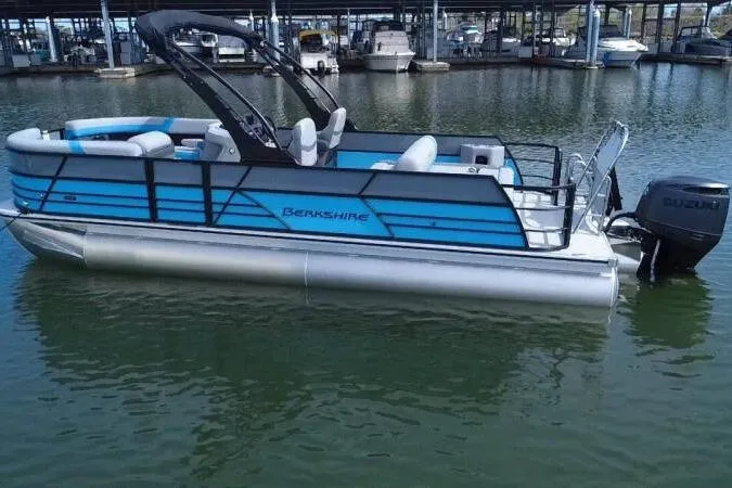 Slide: The Image of 2026 Berkshire CTS Series 24UL pontoon boat docked on calm water. - 8