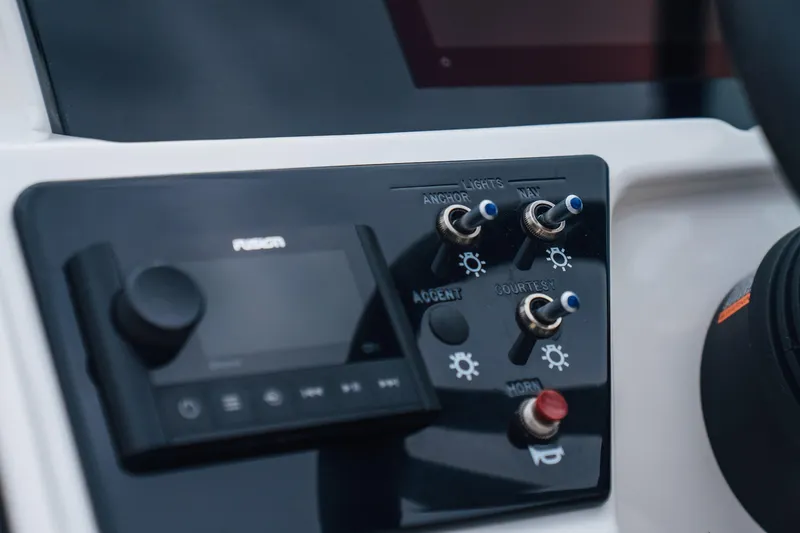 Slide: The Image of Control panel of 2023 Sea Ray SPX 230 boat with switches and audio system. - 12