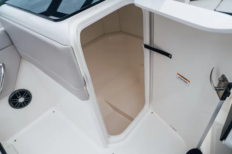 Slide: The Image of 2023 Sea Ray SPX 230 boat interior storage compartment, featuring sleek white design. - 13