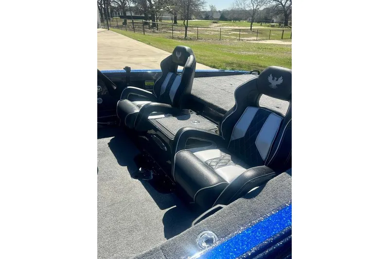 Slide: The Image of 2026 Phoenix 921 Elite X boat interior with black and white seats, sunny outdoor setting. - 4