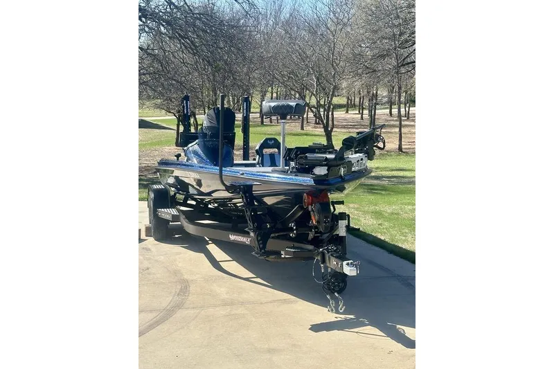 Slide: The Image of 2026 Phoenix 921 Elite X boat on trailer, parked outdoors in a sunny setting. - 6