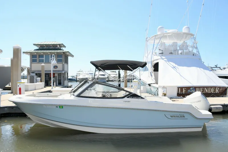 Slide: The Image of 2024 Boston Whaler 210 Vantage boat docked at marina. - 2