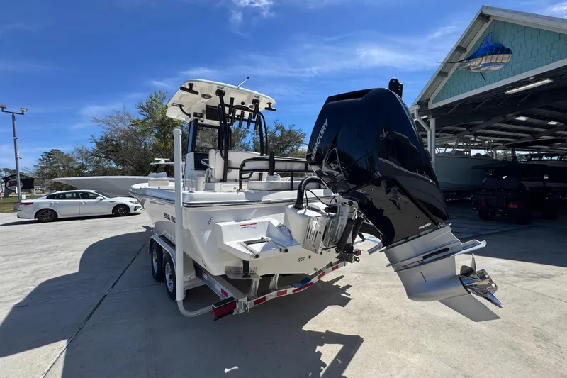 Slide: The Image of 2026 Sea Born FX25 Bay boat with Mercury engine on trailer, parked outdoors. - 14