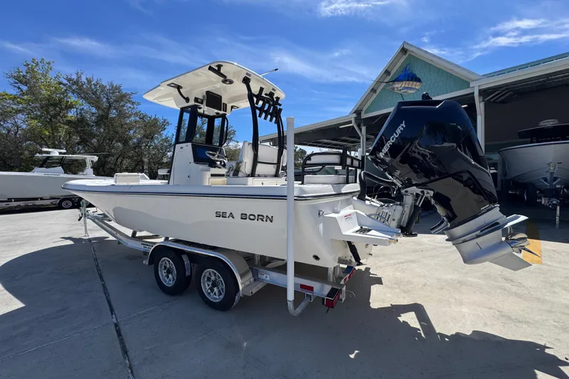 Slide: The Image of 2026 Sea Born FX25 Bay boat with Mercury engine on trailer, parked outdoors. - 15