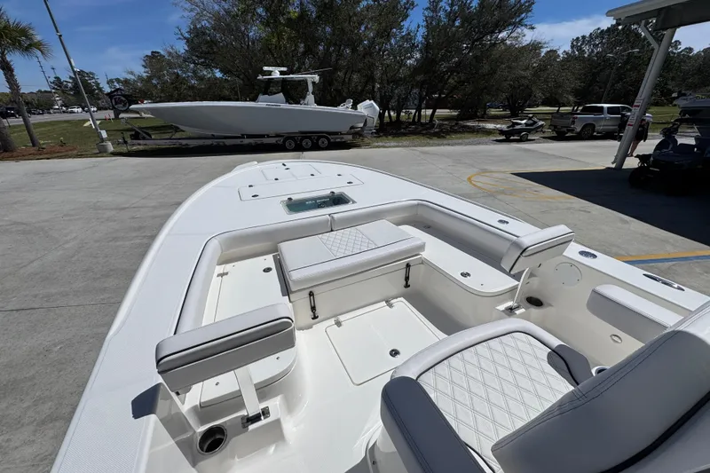 Slide: The Image of 2026 Sea Born FX25 Bay boat interior with seating and storage, parked outdoors. - 18