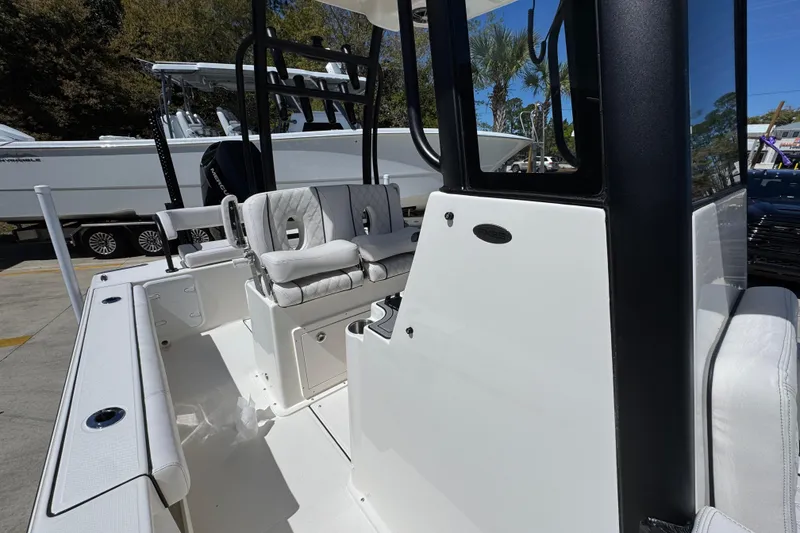 Slide: The Image of 2026 Sea Born FX25 Bay boat interior with seating and console, parked outdoors. - 24