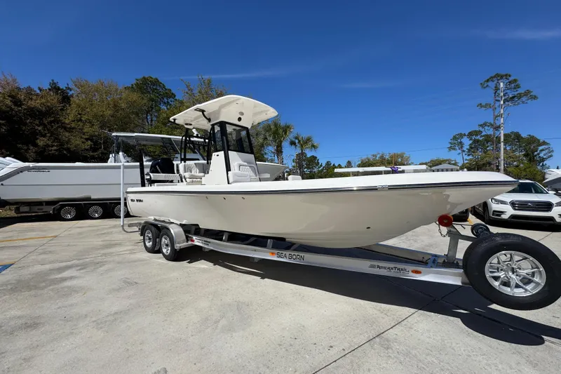 Slide: The Image of 2026 Sea Born FX25 Bay boat on trailer, parked outdoors under clear blue sky. - 7