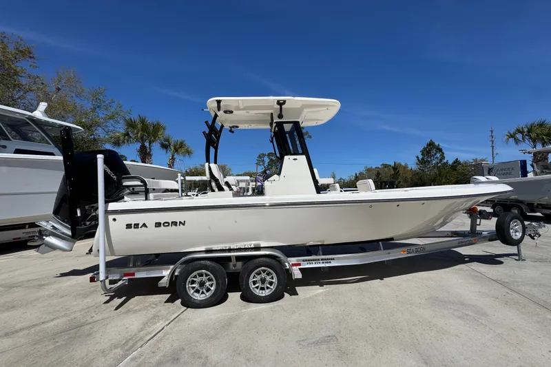 Slide: The Image of 2026 Sea Born FX25 Bay boat on trailer under clear blue sky. - 9