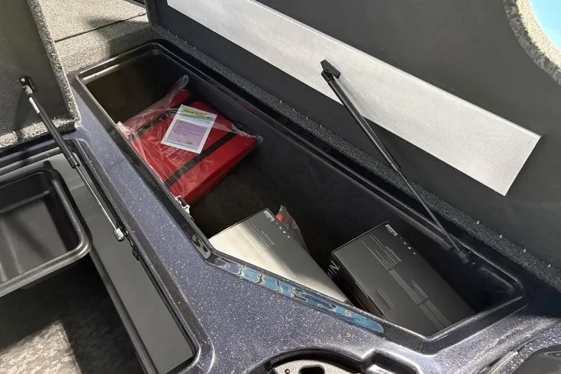 Slide: The Image of Open storage compartment in 2026 Nitro Z19 XL Pro boat, containing safety equipment and boxes. - 16
