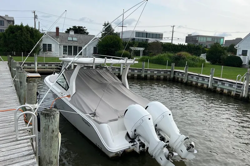 Slide: The Image of 2023 Edgewater 262CX Crossover boat docked with twin engines, covered deck. - 1