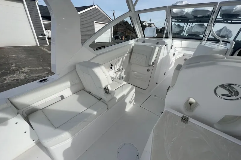 Slide: The Image of 2023 Edgewater 262CX Crossover boat interior with white seating and modern design. - 10