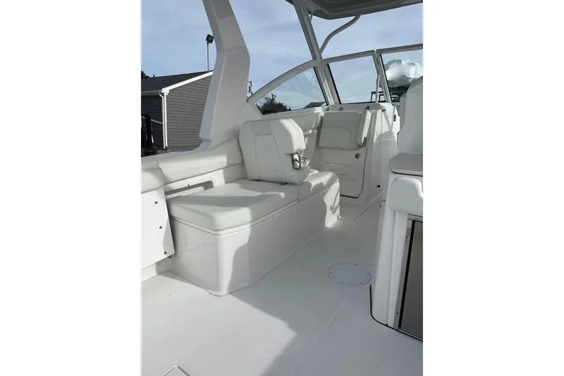 Slide: The Image of 2023 Edgewater 262CX Crossover boat interior with white seating and modern design. - 11