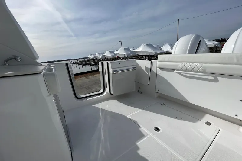 Slide: The Image of 2023 Edgewater 262CX Crossover boat interior with open door, dockside view. - 13