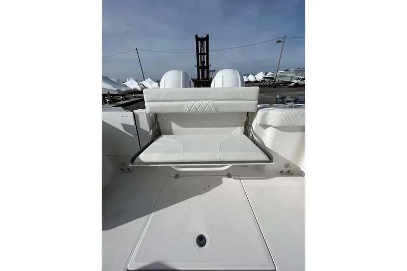 Slide: The Image of 2023 Edgewater 262CX Crossover boat interior with white seating and storage area. - 14