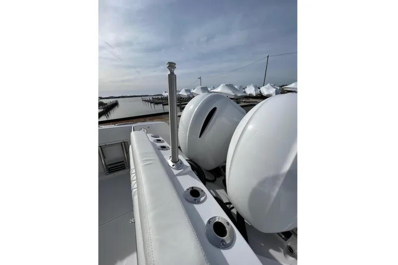 Slide: The Image of 2023 Edgewater 262CX Crossover boat with dual engines docked by the water. - 18