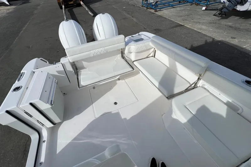 Slide: The Image of 2023 Edgewater 262CX Crossover boat interior with white seating and dual engines. - 23