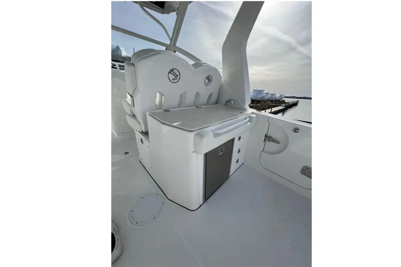 Slide: The Image of 2023 Edgewater 262CX Crossover boat interior with seating and storage, dockside view. - 24