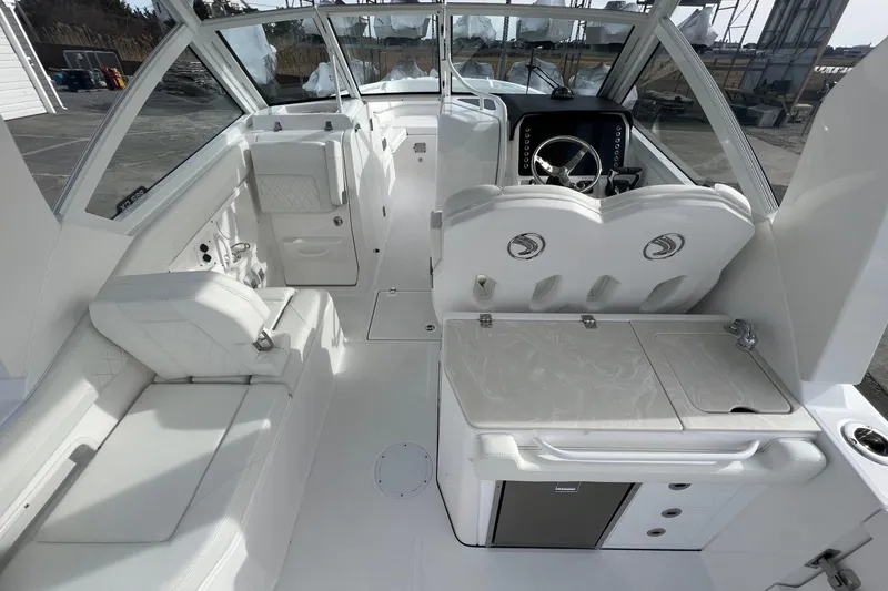 Slide: The Image of 2023 Edgewater 262CX Crossover boat interior with white seating and modern helm. - 25