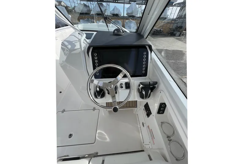 Slide: The Image of Helm of 2023 Edgewater 262CX Crossover boat with steering wheel and control panel. - 3