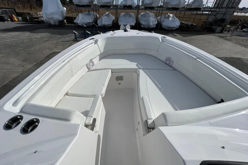 Slide: The Image of 2023 Edgewater 262CX Crossover boat interior with white seating and storage compartments. - 8