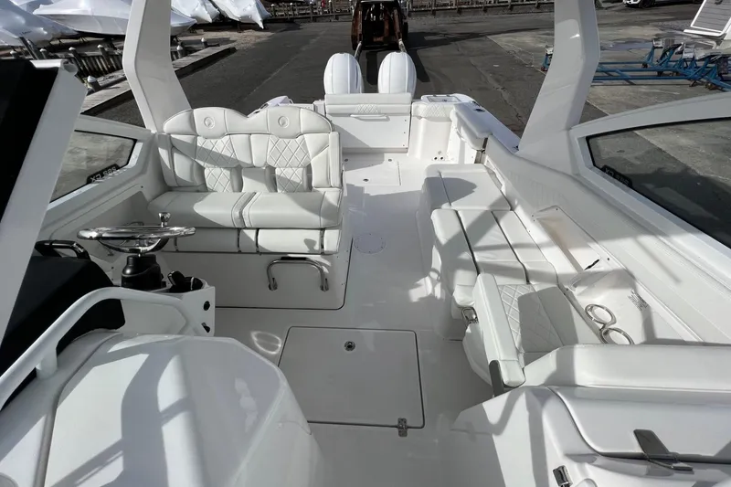Slide: The Image of 2023 Edgewater 262CX Crossover boat interior with white seating and modern design. - 9