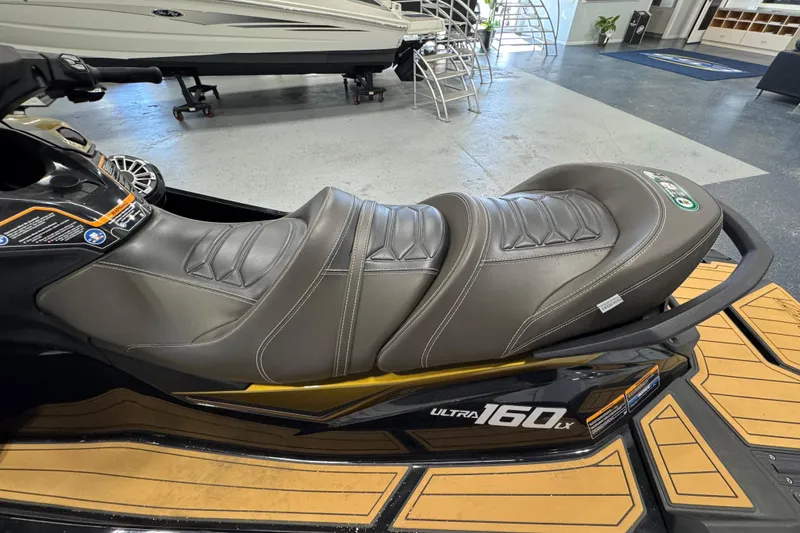 Slide: The Image of 2023 Kawasaki Ultra LX jet ski with sleek leather seating in a showroom. - 5