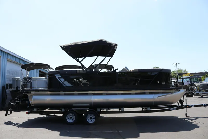 The Image of 2025 SunChaser Geneva Sport 23 LR PSB pontoon boat on trailer, outdoor setting. - 0