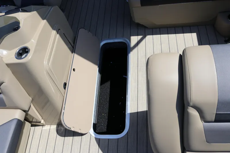 Slide: The Image of SunChaser Geneva Sport 23 LR PSB 2025 boat interior with open storage compartment. - 37