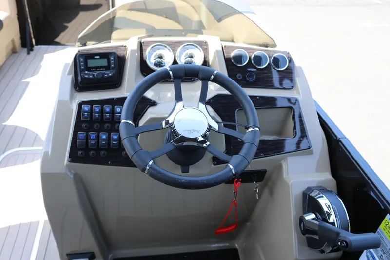 The Image of 2025 SunChaser Geneva Sport 23 LR PSB boat dashboard with steering wheel and controls. - 9