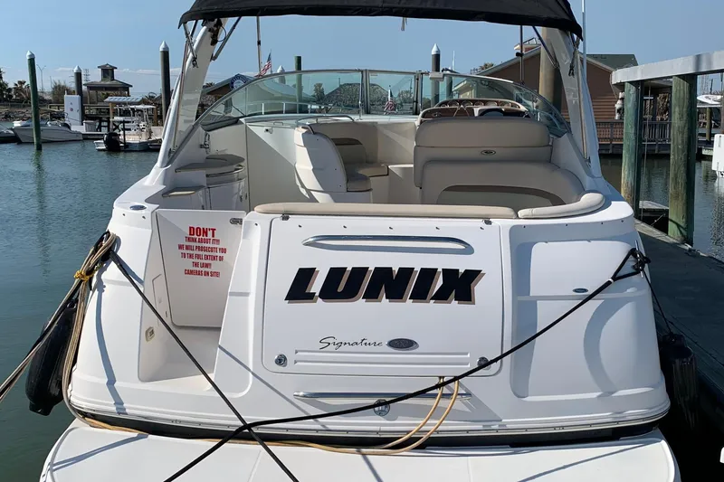 Slide: The Image of 2006 Chaparral Signature 350 boat docked, rear view with "LUNIX" name visible. - 5