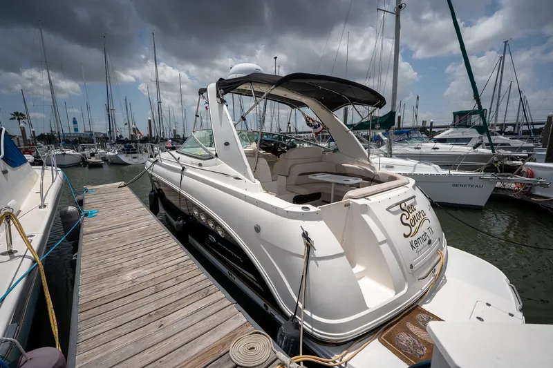 The Image of 2006 Chaparral Signature 350 yacht docked at marina under cloudy sky. - 2