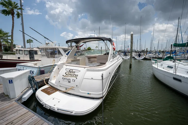 Slide: The Image of 2006 Chaparral Signature 350 boat docked in Kemah, TX marina under cloudy sky. - 1