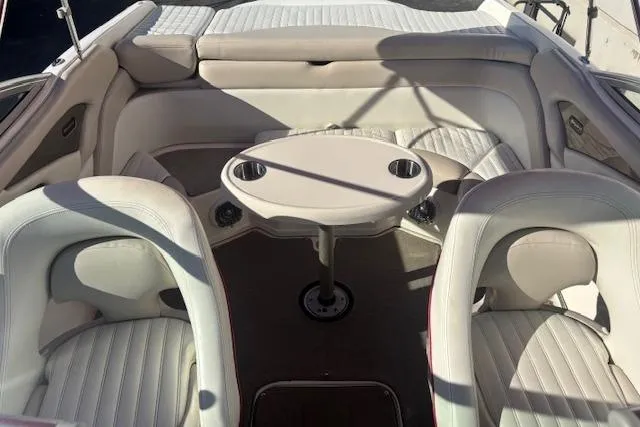 Slide: The Image of Interior of a 2006 Bryant 219 boat with white seating and a central table. - 4