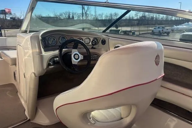 Slide: The Image of Interior of a 2006 Bryant 219 boat featuring a sleek dashboard and steering wheel. - 6