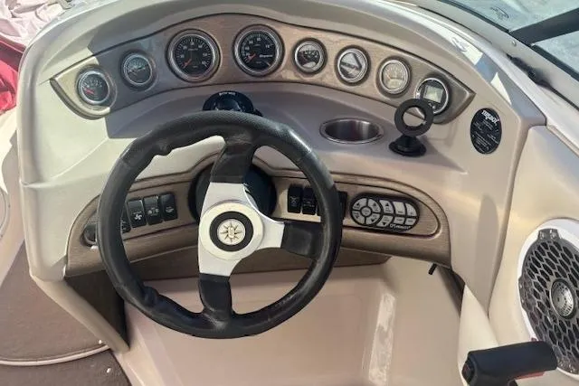 Slide: The Image of Steering wheel and dashboard of a 2006 Bryant 219 boat with gauges and controls. - 7
